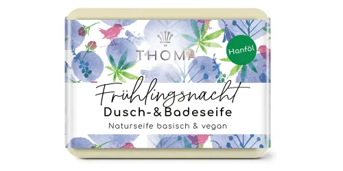 rechteckige, cremefarbene Seife mit blauer blumiger Verpackung und Aufschrift Fruehlingsnacht, Dusch und Badeseife von der Naturseifen Manufaktur Uckermark.